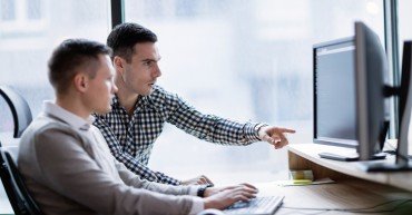 Picture of businesspeople working on computer together in office