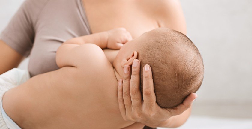 Mother breastfeeding and hugging her newborn baby. Lactation infant concept