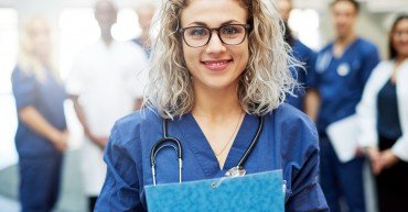Portrait of young woman wearing doctor uniform standing in a hospital.
