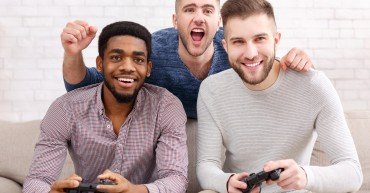 Gamers. Excited men playing video game, meeting and having fun at home